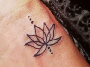 minimalist lotus wrist tattoo — fine-line work